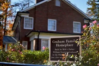Graham Family Homeplace signage in front of building during daytime at Billy Graham Library.
