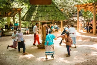 People putting on demonstrations while visitors observe outdoors during daytime.