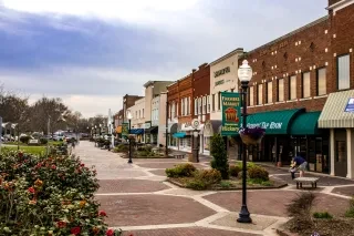 Charming downtown Hickory sidewalk lined with shops and restaurants during daytime.