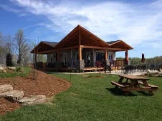 Exterior view of Silver Fork Winery on sunny day with empty patio and lawn in foreground.