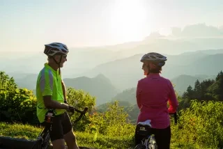 Two people on bikes taking a break on Blue Ridge Parkway to admire view.