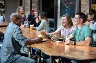 Friends enjoying beers on patio at Pinehurst Brewing Company.