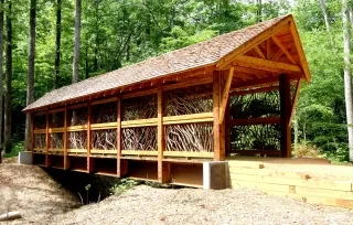 Ccovered bridge on Fonta Flora State Trail in the woods.
