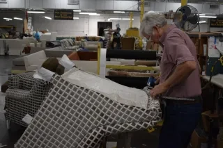 Man working on upholstery in furniture showroom in Hickory.
