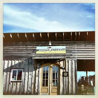 Exterior of farm store with signage above door during daytime.