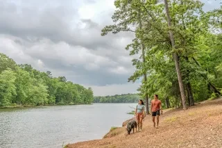 Couple walking dog along Badin Lake scenic path in Uwharrie National Forest.