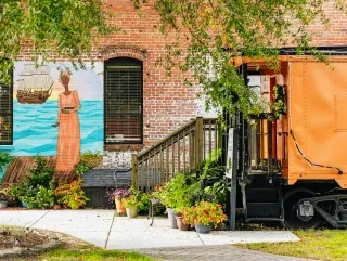 Exterior of Underground Railroad Museum with plants on ground and mural on wall
