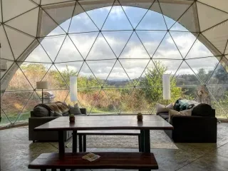 Interior of Asheville Glamping dome with living room looking out onto mountainous terrain.